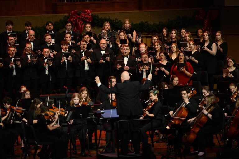 students and faculty singing on stage in Centennial Chapel
