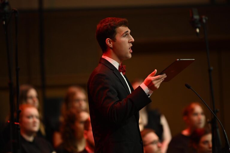Male student singing on stage