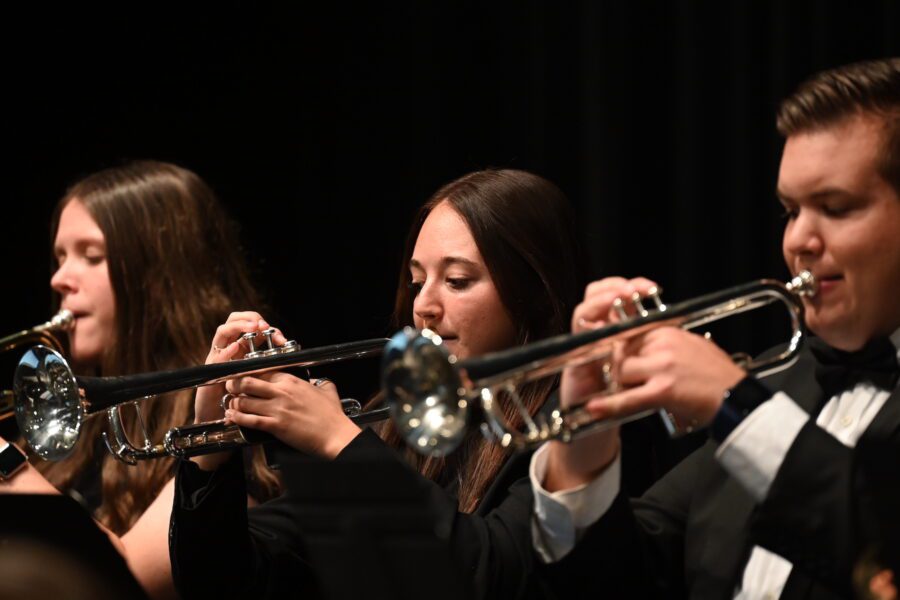 3 students playing the trumpet