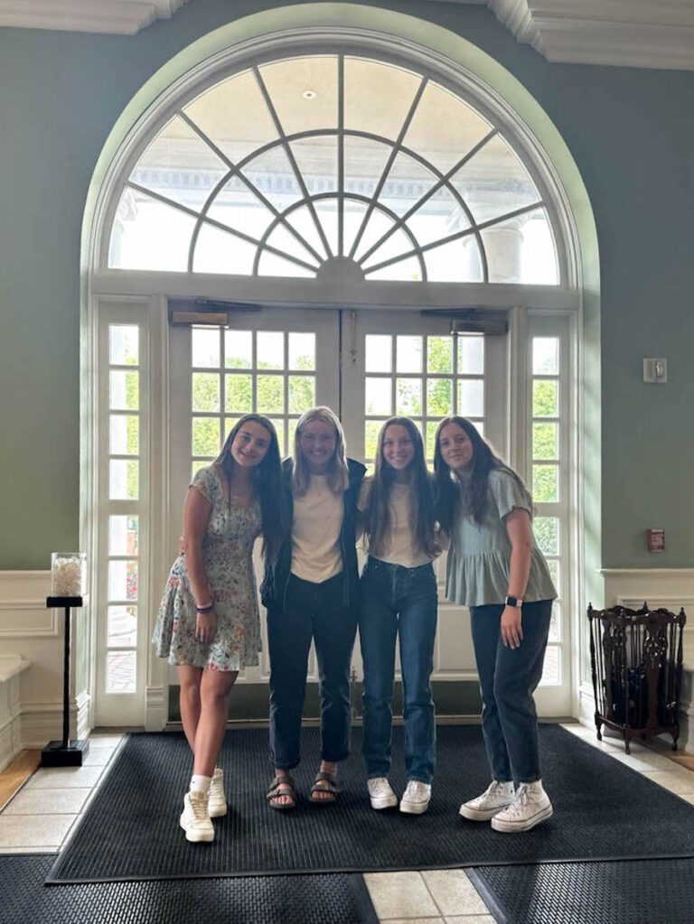 four girls posing in the Admissions Main building