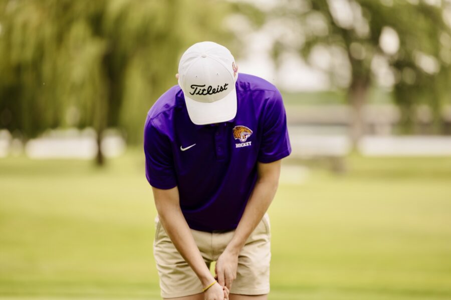 male student golfing