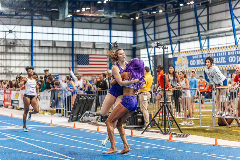 women celebrating track and field relay victory