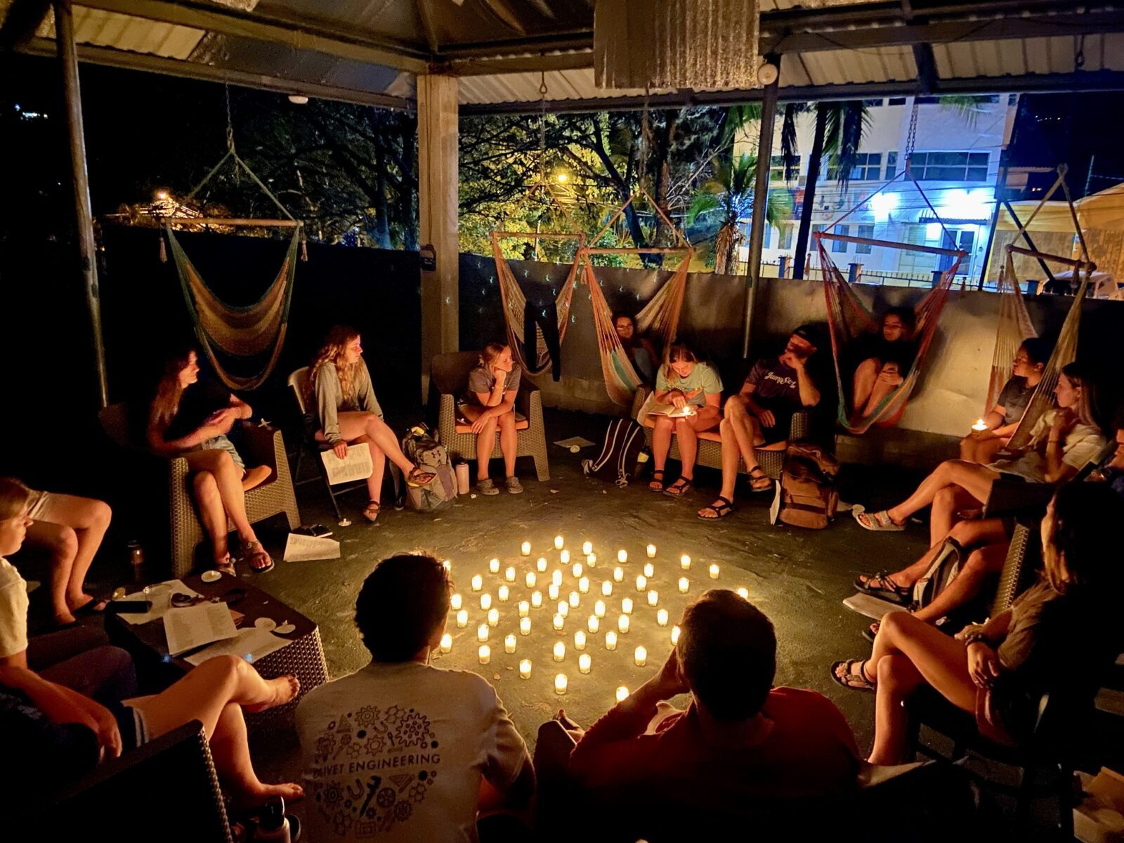 students sitting in circle around candles for debrief