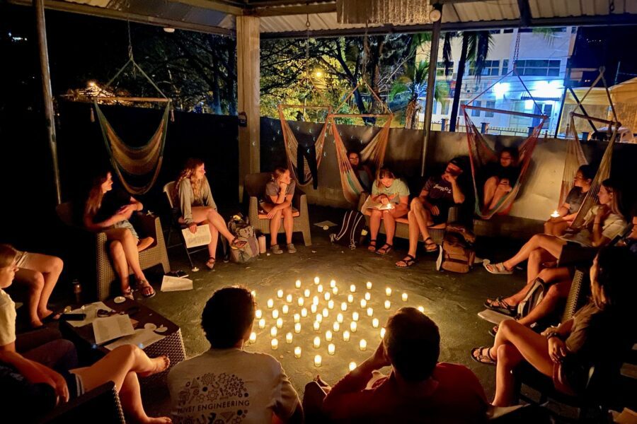 students sitting in circle around candles for debrief