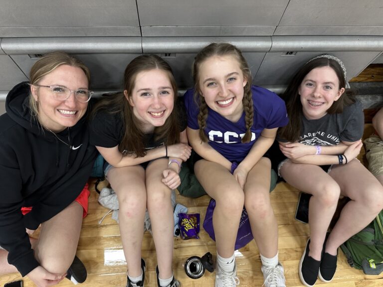 four girls sitting on the floor smiling