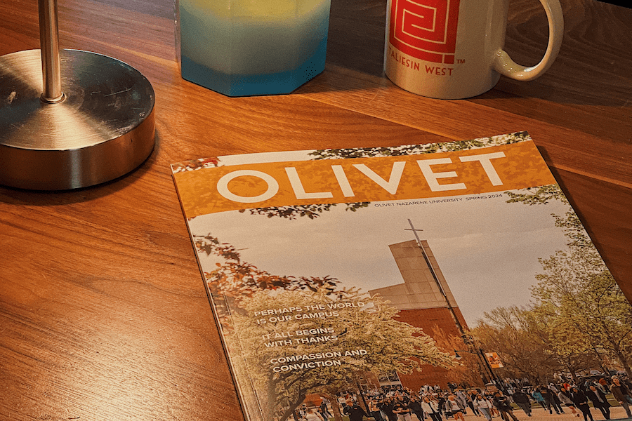 magazine on desk with mug and candle