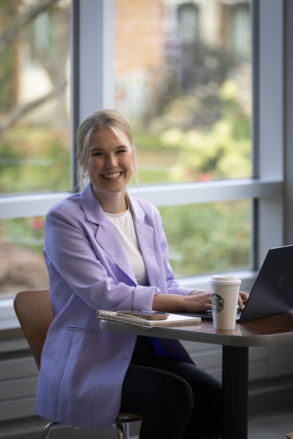Woman in lavender coat smiling