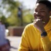 male student holding a pencil and smiling