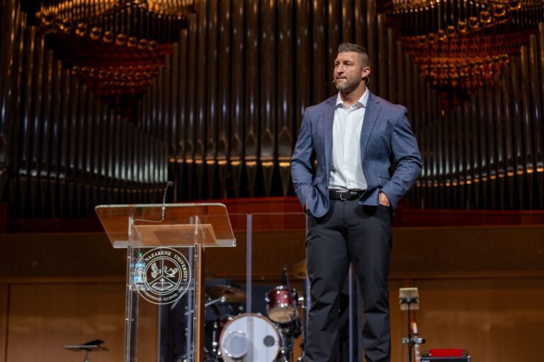 Tim Tebow on stage with his hands in his pockets