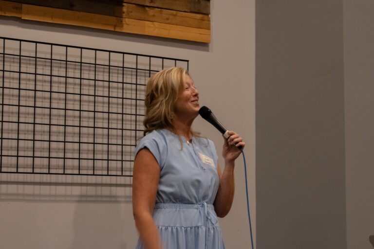 Female speaking to a group while holding a mircophone