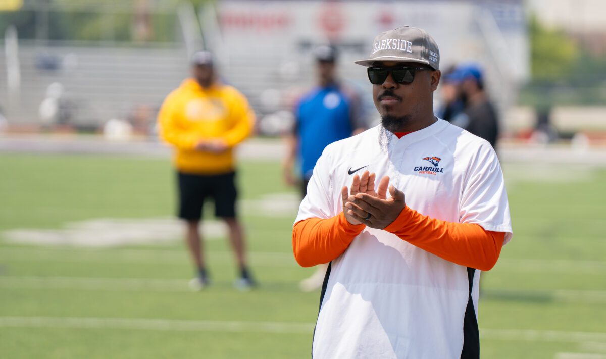 Carroll University football coach claps while observing drills at the 2025 Avante Mitchell Football Mega Camp at Olivet Nazarene University