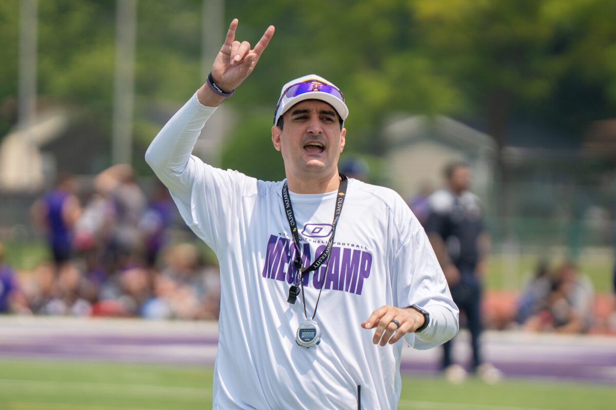 Coach wearing an Avante Mitchell Football Mega Camp shirt gives instructions on the field at the 2025 camp hosted by Olivet Nazarene University

