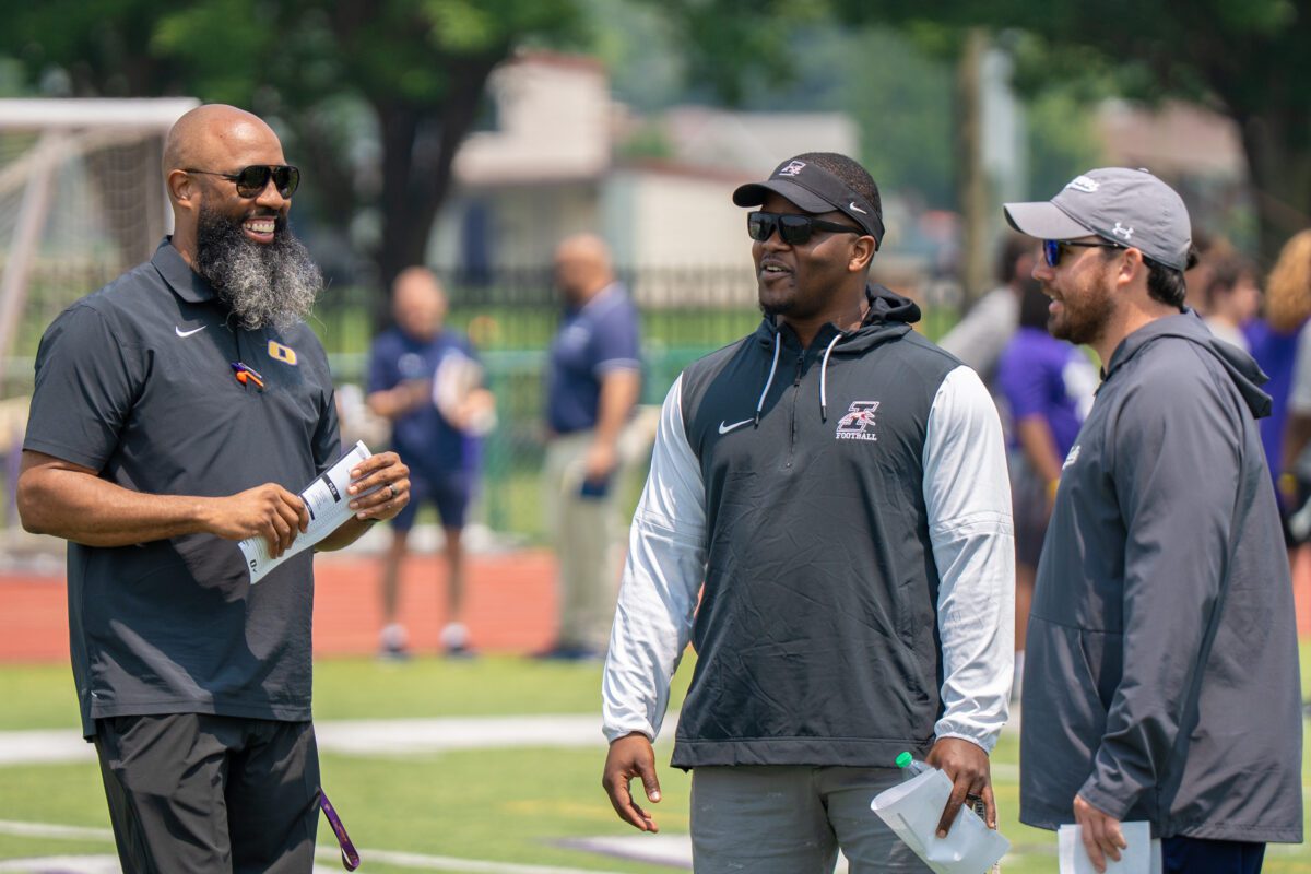 Coaches from Olivet Nazarene University and Southern Illinois University talk on the field during the 2025 Avante Mitchell Football Mega Camp