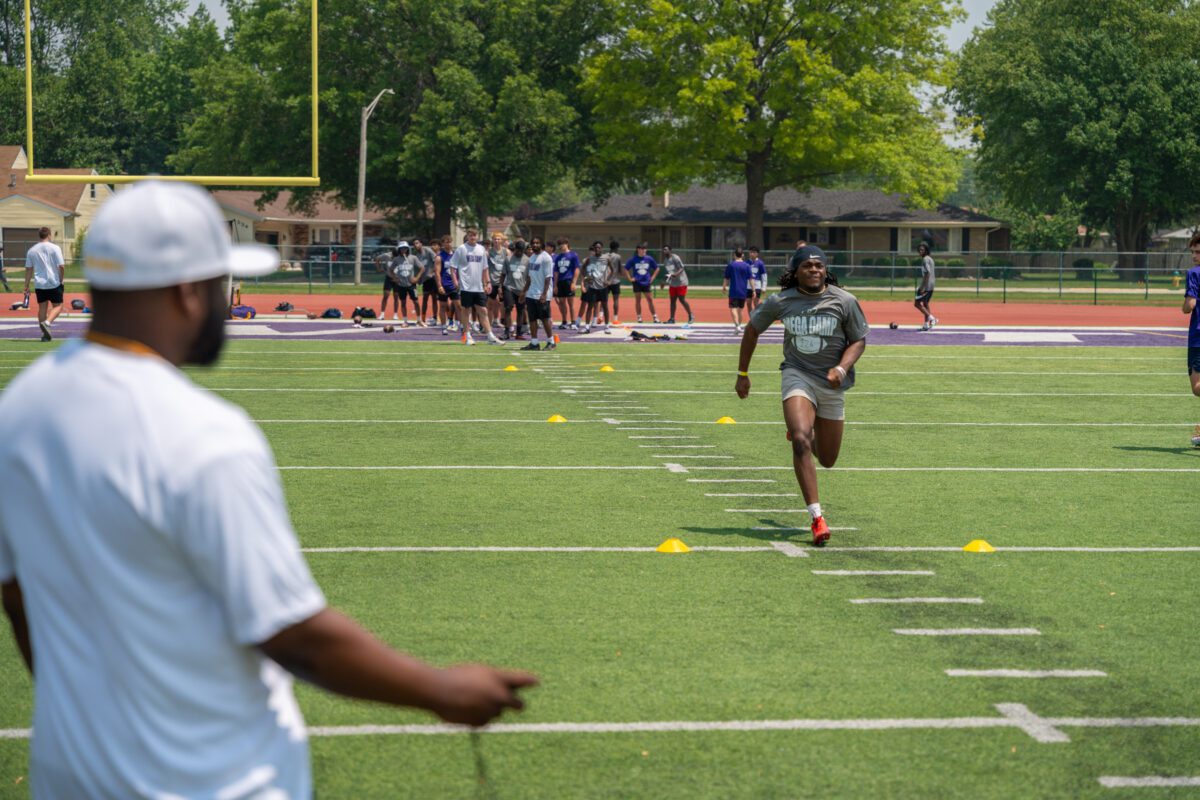 Athlete sprints through a cone drill while a coach times his run at the 2025 Avante Mitchell Football Mega Camp at Olivet Nazarene University

