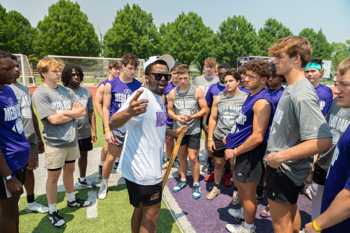 Coach addresses high school football players during a training session at the 2025 Avante Mitchell Football Mega Camp hosted by Olivet Nazarene University

