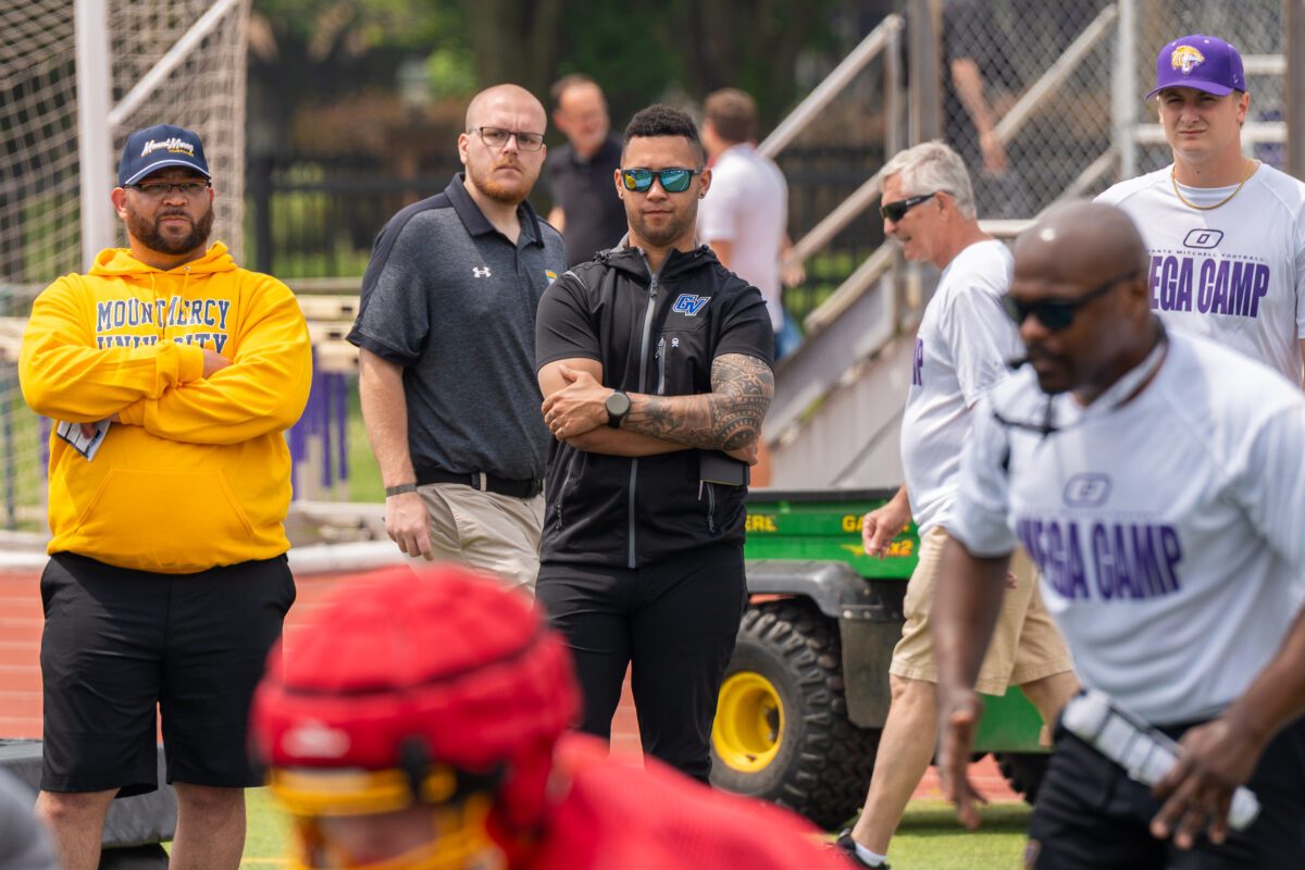 Coaches from Mount Mercy University, Grand Valley State University, and other programs watch lineman drills during the 2025 Avante Mitchell Football Mega Camp at Olivet Nazarene University