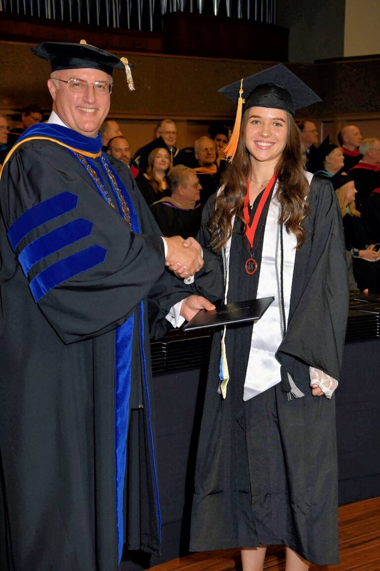 Female student shaking hands with University President Gregg Chenoweth