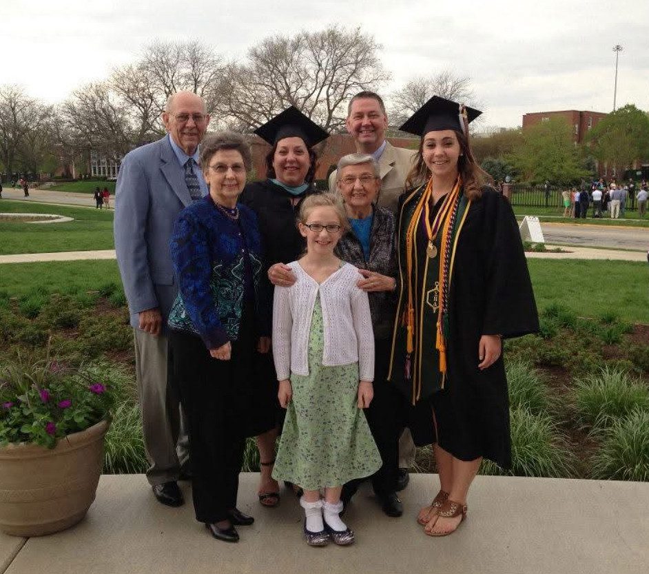Family smiling after graduation with two graduates
