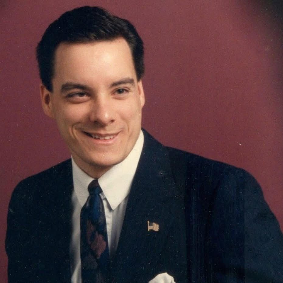 Man standing in front of a background for a school picture