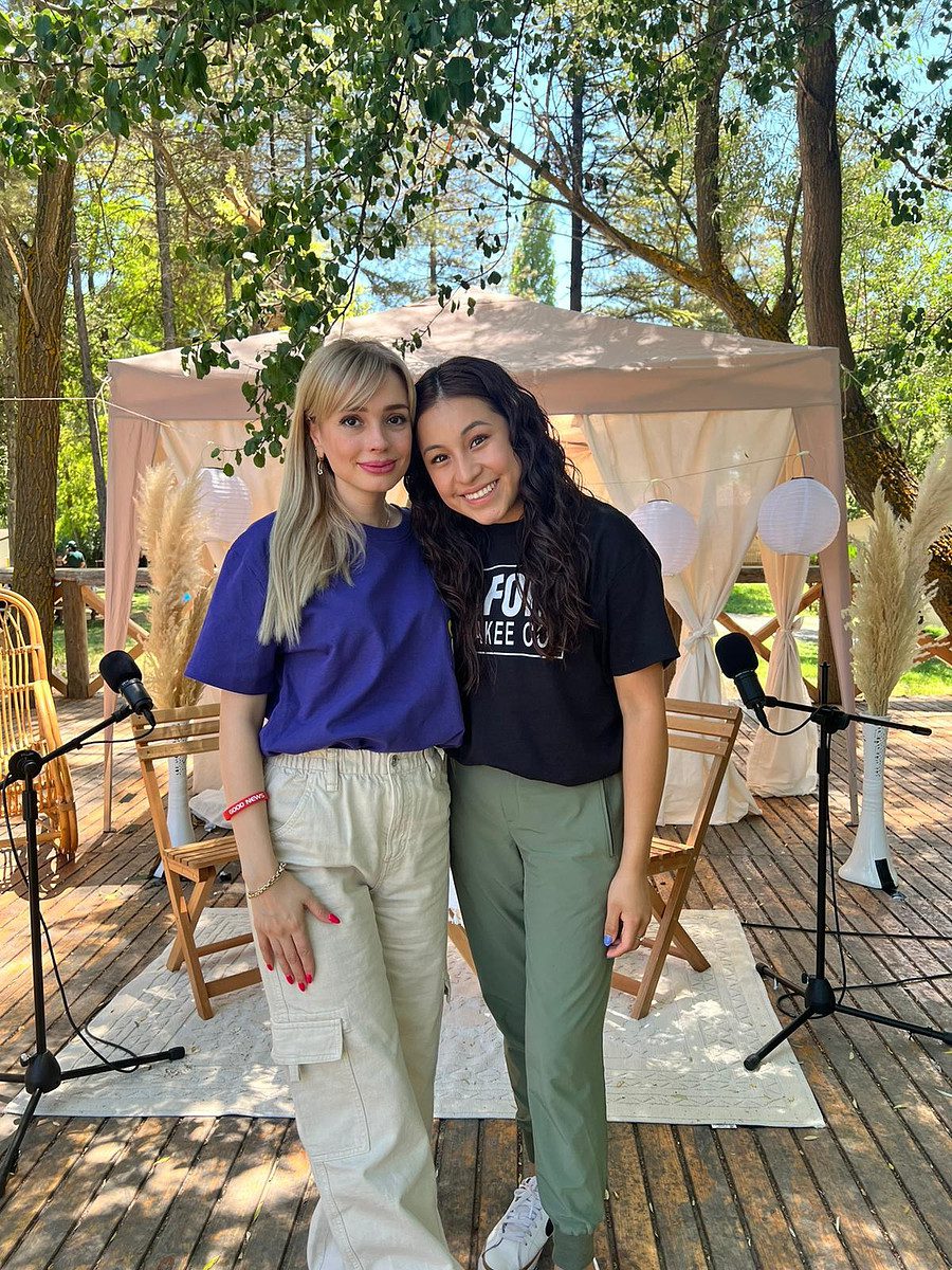 Two women taking a picture in a garden
