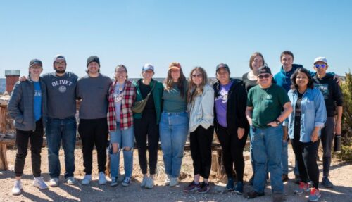Group of people taking a picture on top of a hill