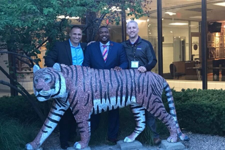 Will Akin with cohort in front of of a tiger statue