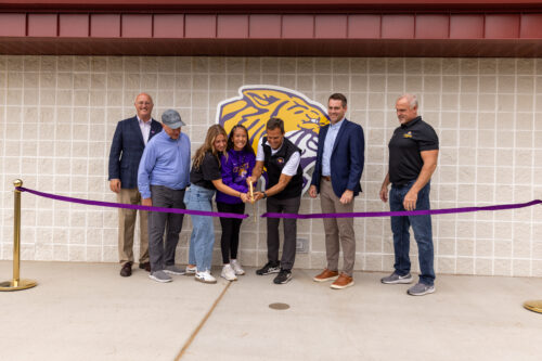 Bill Bahr, players, athletic department staff, and Dr. Chenoweth cutting the ribbon