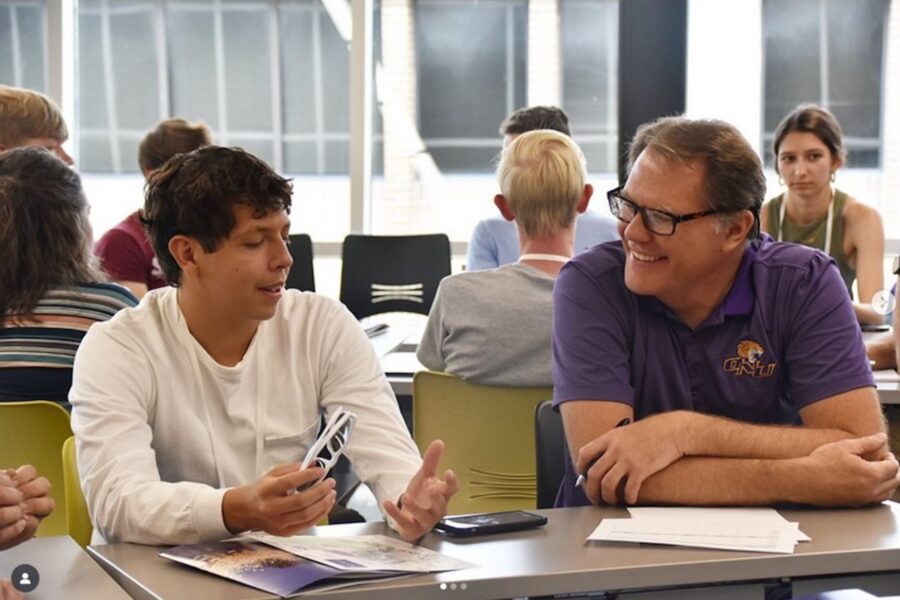 Professor Scott Ragan sitting and talking with a student.