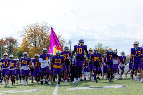 Olivet Football running off the field after planting a Tiger flag in the field