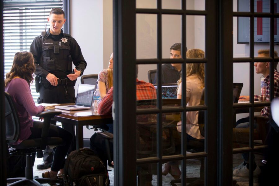 A police officer talking to criminal justice majors about his professional experiences