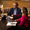 Two women and a man studying in a coffee shop.