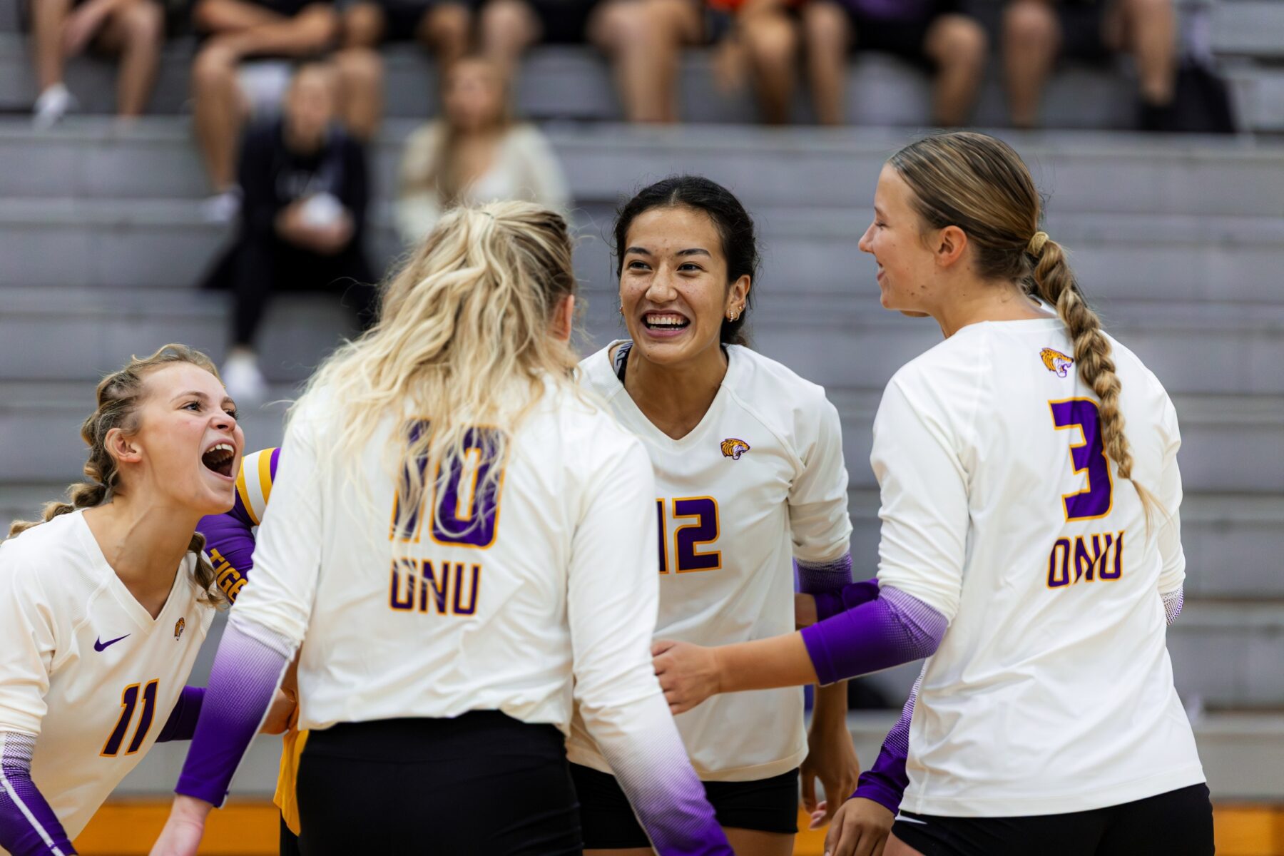 Four women in white ONU volleyball uniforms