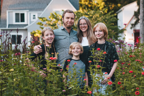 Janie and her family taking a picture in a garden.