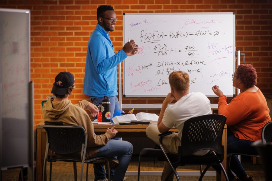 A teacher teaching students a math problem.
