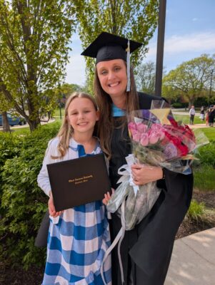 Elizabeth holding her diploma after her graduation.
