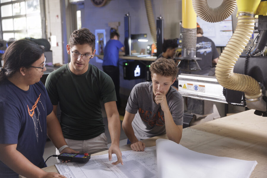 Three people looking over plans on a table