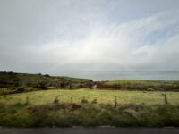 A picture of the Ireland countryside and a rainbow going across the picture.