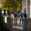 Professor talking to three students right outside a building