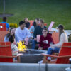 group of students sitting around a firepit