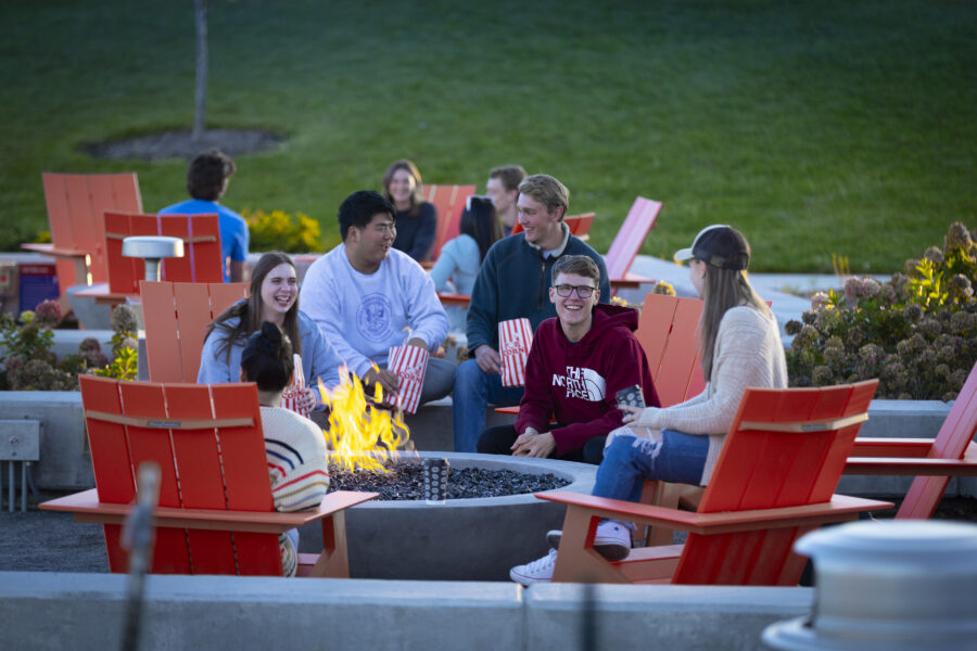 group of students sitting around a firepit
