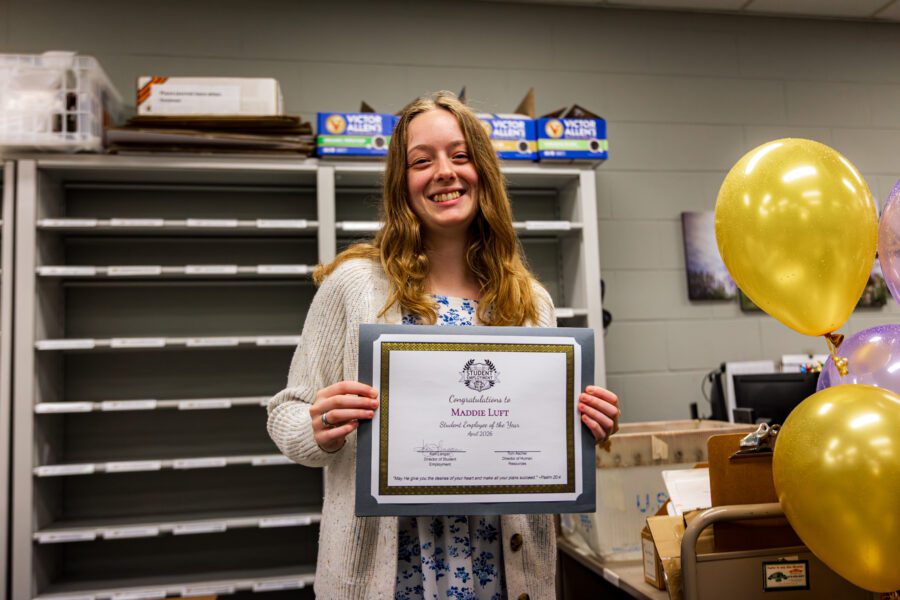 Maddie Luft holding her award for student employee of the year.