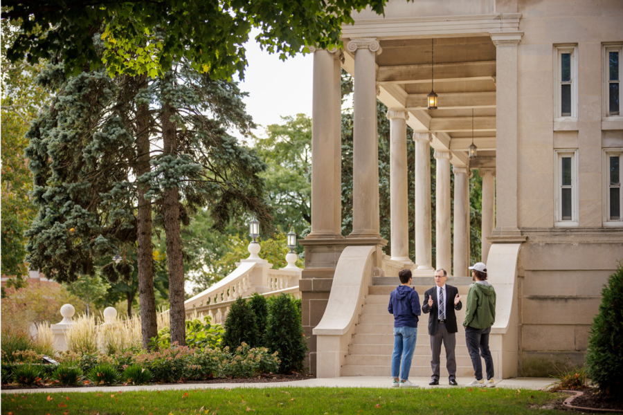 Dr. Kent Olney talking with two students in front of Burke