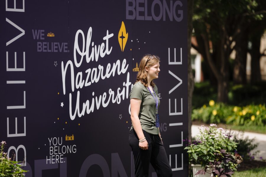 girl standing in front of olivet banner