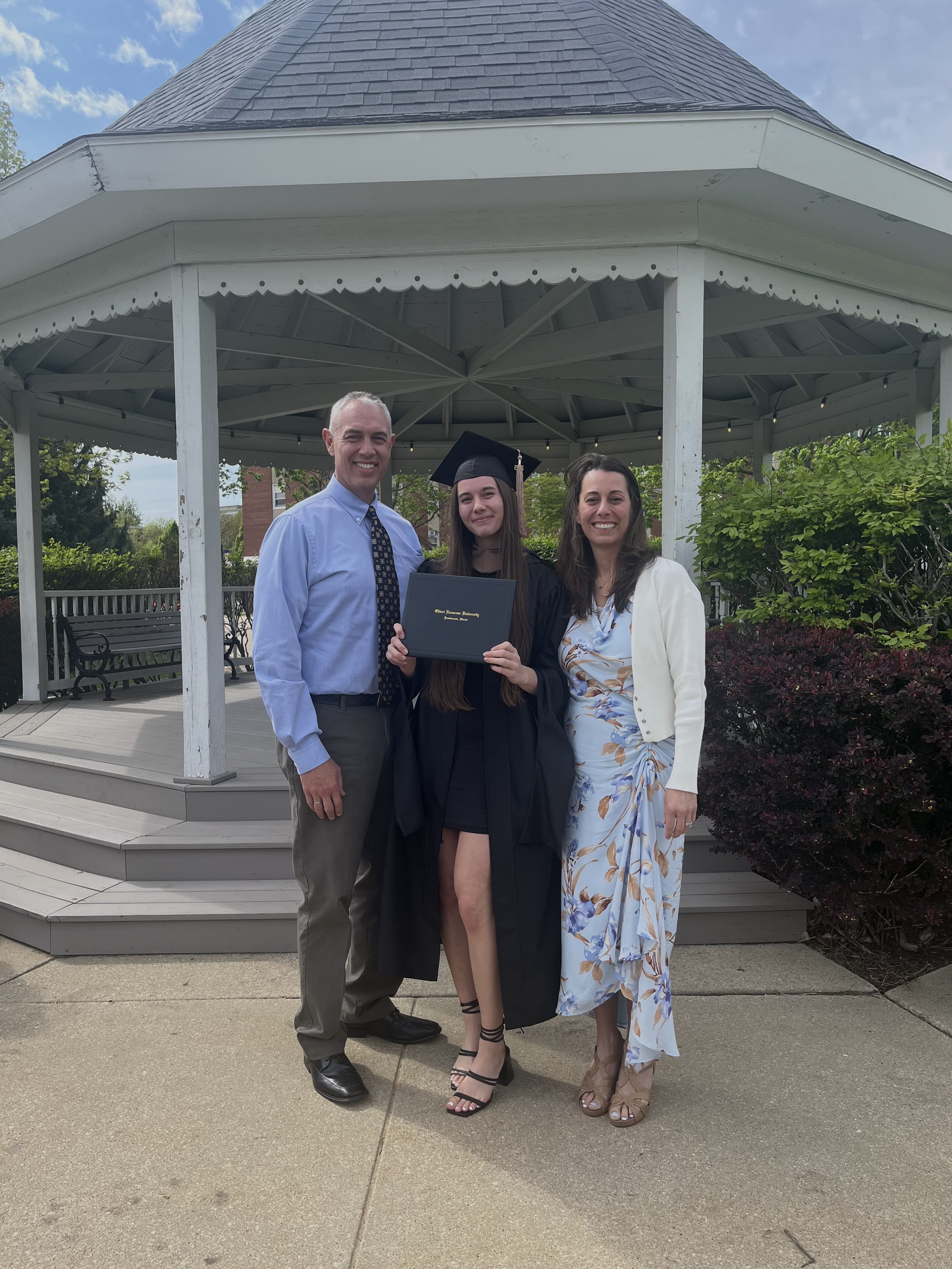 Mia with parents after Graduation.