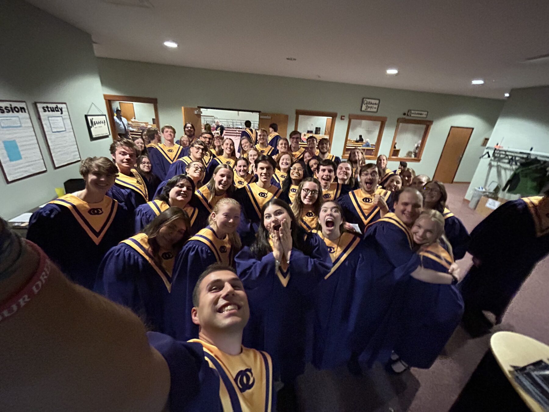 A picture of cole and people from the choir in their choir robes.