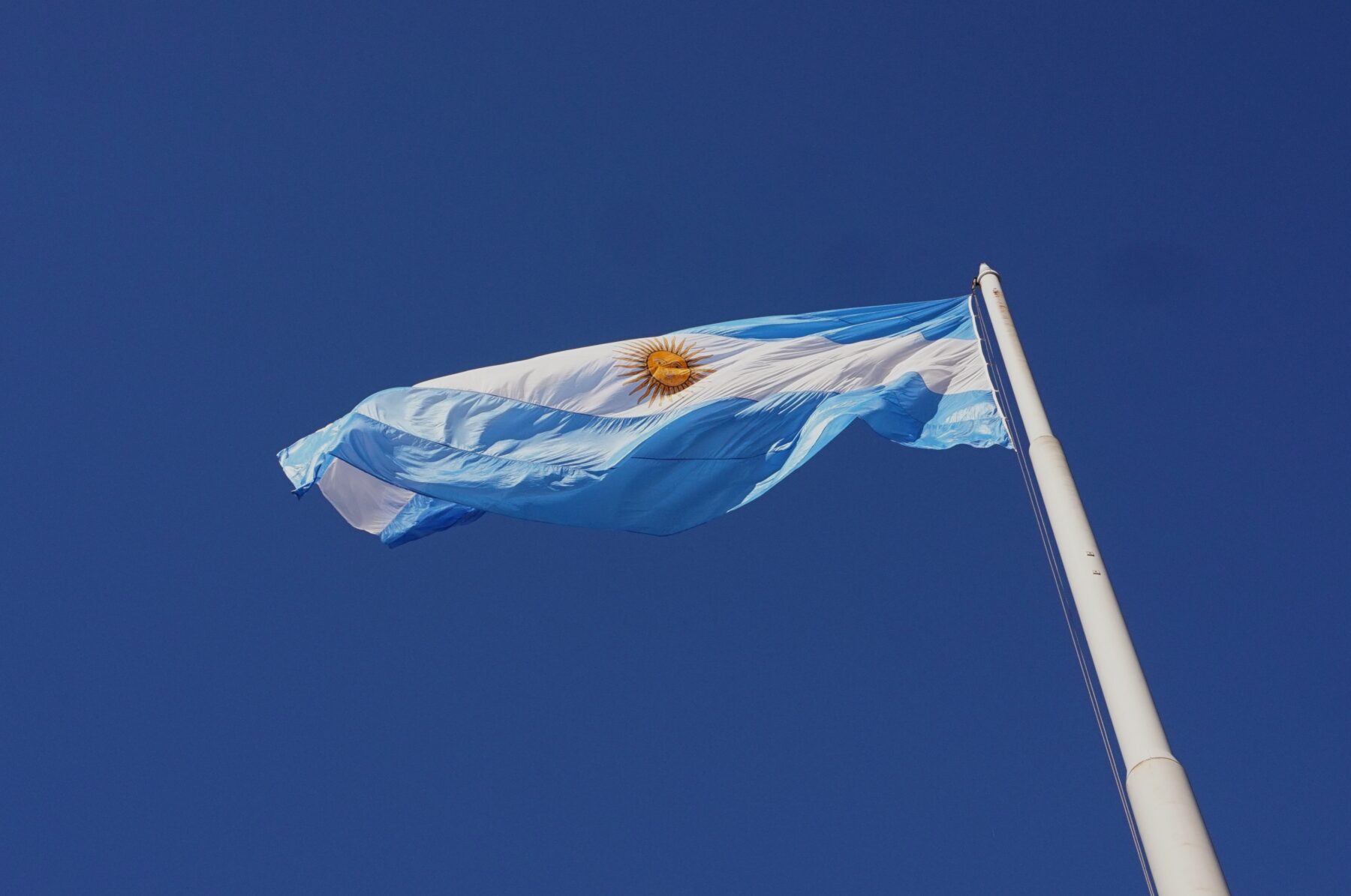 A picture looking up at an Argentine flag.