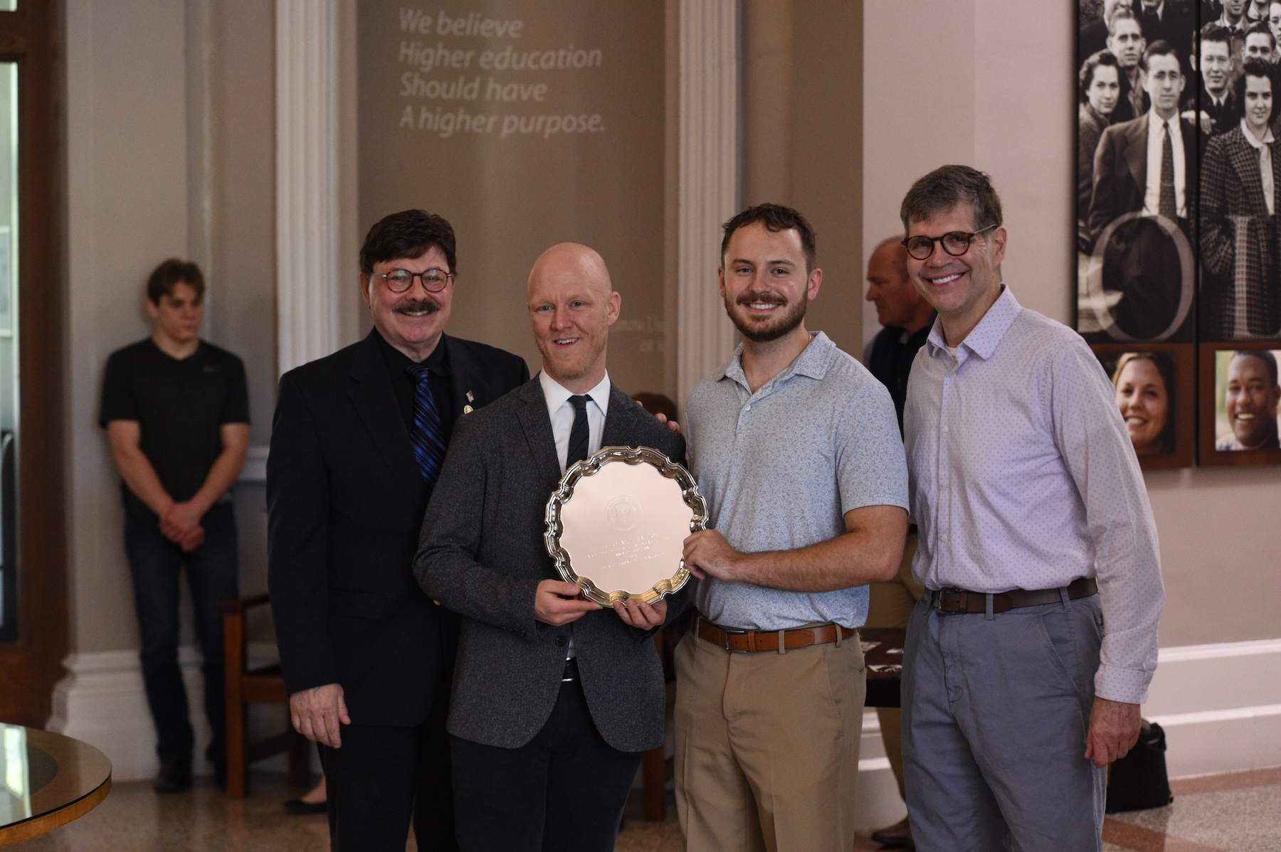 Nicholas and three people from Olivet presenting him with his award