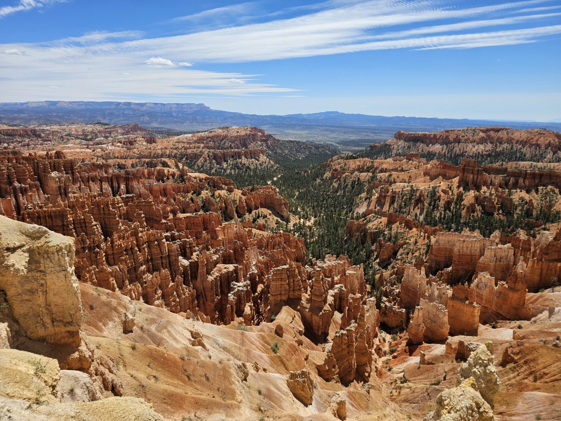 A picture of Bryce Canyon on a day with blue skies and some clouds.